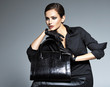 © Valua Vitaly - Beautiful woman in black  holds fashion handbag
