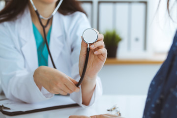 Doctor with a stethoscope in the hand. Physician is ready to examine her female patient.