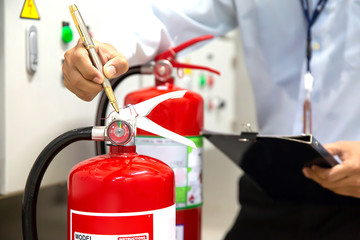 Wall Mural - Engineer are checking and inspection a fire extinguishers in the fire control room for safety and prevention.