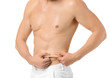 © Pixel-Shot - Handsome young man touching fat on his belly against white background. Plastic surgery concept