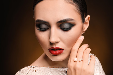 Young woman with beautiful makeup on dark background