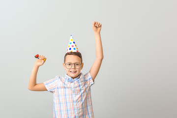 Cute little boy celebrating Birthday on light background