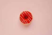 Red Fake Rubber Donut On Pink Background.