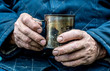 Working men's hands. A man holds a metal mug in his hands.