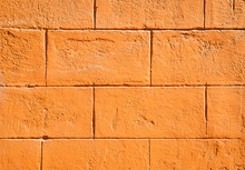 Full Frame Background Of Brightly Colored Orange Block Wall With Sunny Texture Copy Space