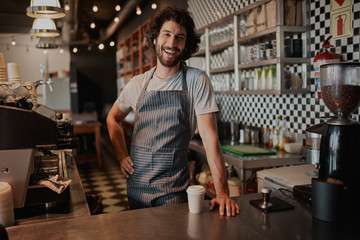 Handsome male barista is working in coffee shop