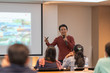 © Pornchai - Asian Speaker is speaking on the stage over the presentation screen in the education seminar