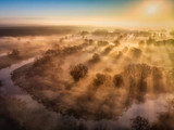 Promienie słońca wśród mgieł nad starorzeczem Warty