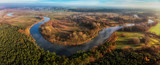 Wijąca się rzeka Warta wśród łąk i lasów Wielkopolski, widok z lotu ptaka