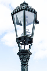 Old street lamp against sky.