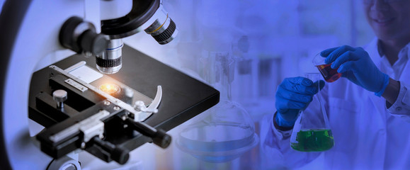 Wall Mural - laboratory concept; close up of microscope with a blurred picture of the scientist is researching in