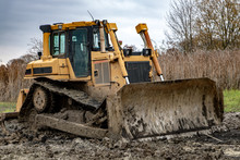 Dirty Bulldozer Standing In The Mud. Autumn Construction Site With Working Machines.