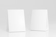 © Kakabe - Promotional table talker isolated on white background, mockup template paper tri-fold vertical triangle cards with reflections. white sheets front & left and right view. 3d render
