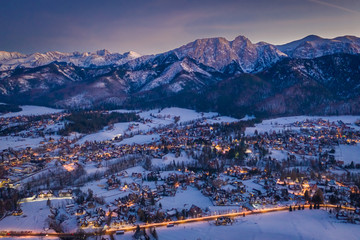 Wall Mural - Stunning illuminated Zakopane city after dusk in winter, aerial view
