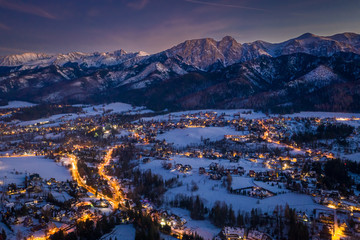 Wall Mural - Stunning illuminated Zakopane city in winter at night, aerial view