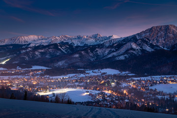 Wall Mural - Amazing illuminated Zakopane city after dusk in winter, aerial view