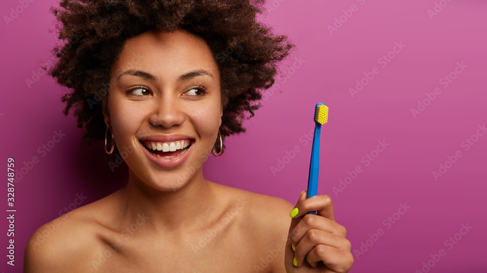 Daily routine and dental hygiene concept. Pretty shirtless dark skinned