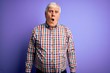 © Krakenimages.com - Senior handsome hoary man wearing casual colorful shirt over isolated purple background In shock face, looking skeptical and sarcastic, surprised with open mouth