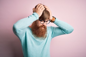 Canvas Print - Handsome Irish redhead man with beard wearing glasses over pink isolated background suffering from headache desperate and stressed because pain and migraine. Hands on head.