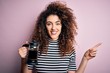 © Krakenimages.com - Young beautiful woman with curly hair and piercing doing coffee holding french coffeemaker very happy pointing with hand and finger to the side