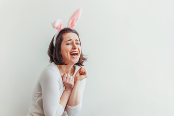 Wall Mural - Happy Easter holiday celebration spring concept. Young woman wearing bunny ears isolated on white background. Preparation for holiday. Girl looking happy and excited, having fun on Easter day