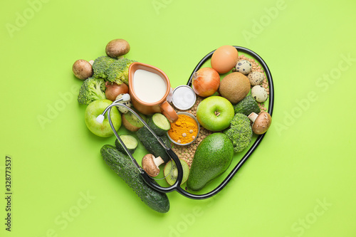 Cuadros en Lienzo Healthy products and stethoscope in shape of heart on color background