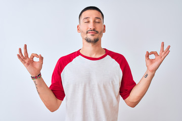 Wall Mural - Young handsome man standing over isolated background relax and smiling with eyes closed doing meditation gesture with fingers. Yoga concept.