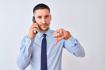 Sticker - Young handsome business man calling using smartphone over isolated background with angry face, negative sign showing dislike with thumbs down, rejection concept