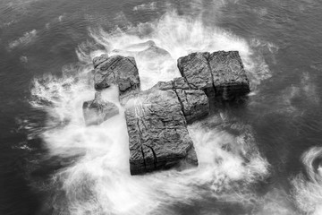 Wall Mural - Black and white photo of  a rock in the ocean