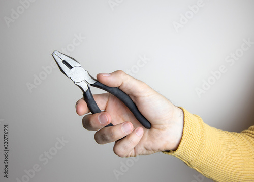 Mockup image of man's hands holding a pliers wearing a yellow sweater over blank Poster Mural XXL