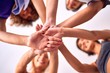 © Krakenimages.com - Young beautiful group of sportswomen standing shaking hands after class of yoga at gym