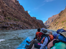 River Trip Group Of People Sitting On A Blue S-rig Raft And Looking Downstream On The Colorado River Rapids In The Grand Canyon National Park, Arizona, United States Of America