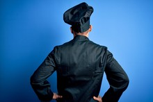 Young Handsome Chef Man Wearing Cooker Uniform And Hat Over Isolated Blue Background Standing Backwards Looking Away With Arms On Body