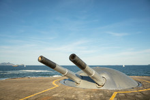 Owl In The War Cannon In Military Fort, Bunker With Defense Canons And Sailboat In The Background At The End Of Copacabana Beach, In Rio De Janeiro