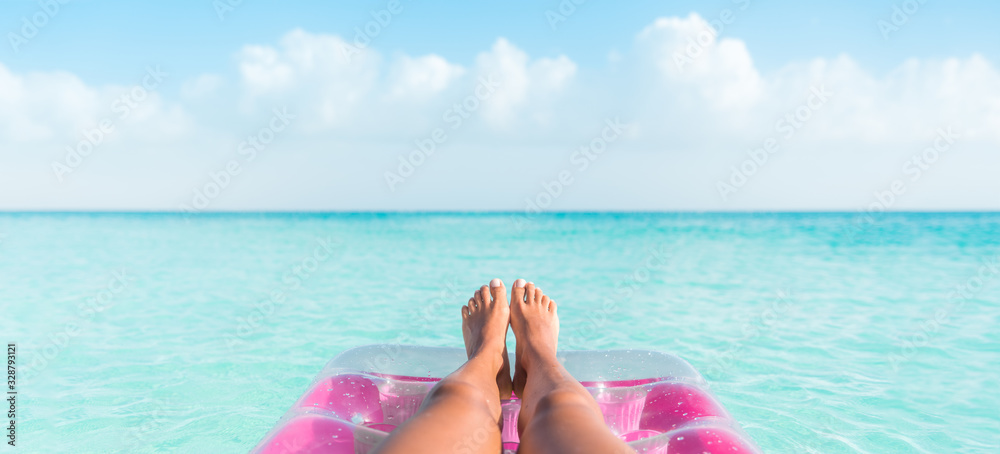 Beach summer vacation woman relaxing on pool float taking feet selfie pov of legs sunbathing relax on pink air mattress inflatable toy floating on blue ocean background panoramic banner. - obrazy, fototapety, plakaty 
