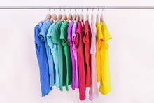 Clothes Hanging On Clothing Rack Wardrobe Fashion Apparel Selection Of Rainbow Color T-shirts On Closet Hangers. Womens Wear In Store Shopping Spring Cleaning Concept. Summer Home Wardrobe.