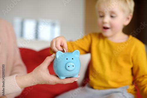 Fotomural Mother and child putting coin into piggy bank