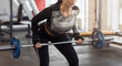 © Prostock-studio - Unrecognizable woman working out with barbell in sports club