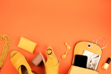 Wall Mural - Flat lay with woman fashion accessories in yellow color over orange yellow textured background. Fashion, online beauty blog, summer style, shopping and trends idea