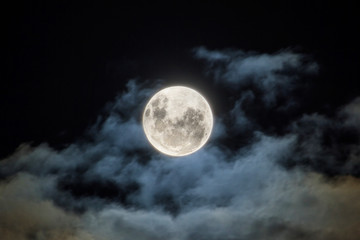 the full moon, with wispy white clouds around it
