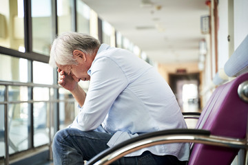 Sticker - devastated senior asian man sitting in hospital hallway