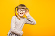 © Svetlana - Little child girl journalist in glasses with surprised euphoria face and funny pigtails listening to something holding his hand to ear