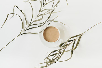 Wall Mural - Stringy green plant and coffee cup on white background.