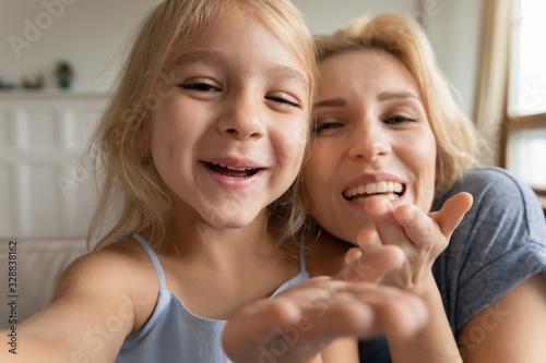 Photographie Cute little preschooler girl and young mother have fun make self-portrait pictur