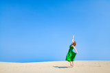 Fototapeta Morze - 緑のドレスを着て砂丘に立つ白人女性