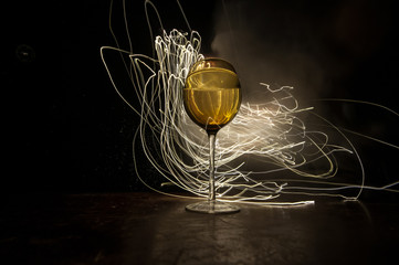 Goblet of white wine on wooden table on wooden wall background