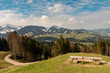 A bench on the Hündle, a peak in the Allgäu, with a magnificent view over snow-covered mountains and green valleys.