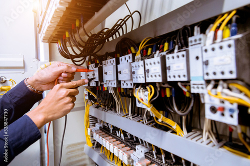 Fotomural Electrician measurements with multimeter testing current electric in control panel