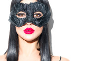 Beauty Sexy Glamour Brunette Woman Portrait. Girl Wearing Carnival Black Feather Mask. Party. Black Hair, Red Lips, Holiday Makeup Christmas And New Year Celebration, Fashion Portrait