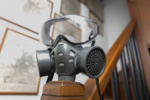Coronavirus Concept: Close Up On A Gas Mask Placed Inside A Domestic Interior.
